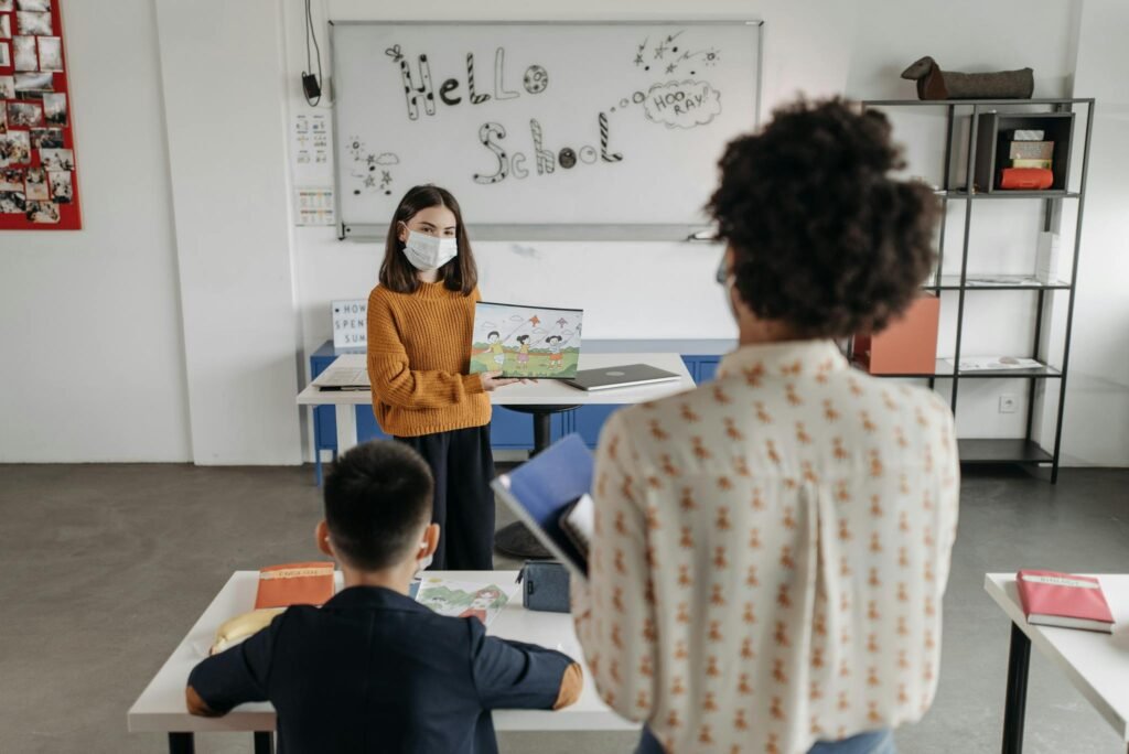 A teacher with a face mask instructs a classroom with students during a lesson.